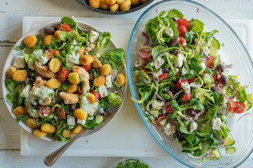 Delicious summer salad with chicken meat, vegetables, feta cheese, gnocchi and dressing