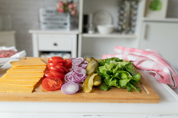 Ingredients for making a cheeseburger on a cutting board