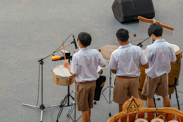 Group of Asian students in uniform perform a orchestra band in festival performance at stadium....
