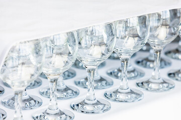 Empty glasses stand on a table covered with white tablecloth
