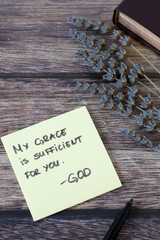 Naklejka premium My grace is sufficient for you, God, handwritten biblical quote with holy bible and lavender on wood. Top view. Spiritual strength, Jesus Christ's power and mercy, Christian concept.