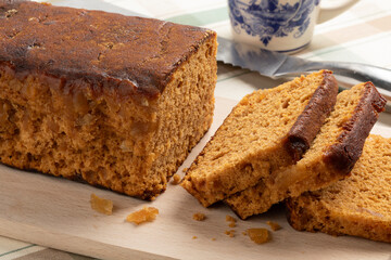Traditional Dutch ginger breakfast cake and slices on a cutting board close up