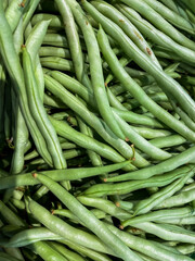 Heap of green pods of raw, not cooked, asparagus beans top view.
