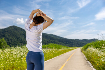 둘레길에서 조깅을 시작하기 전 스트레칭으로 준비운동 하는 여자