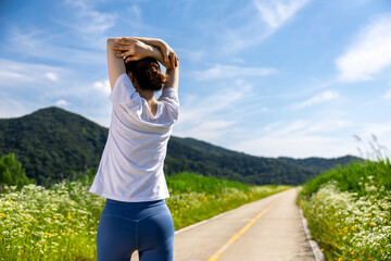 둘레길에서 조깅을 시작하기 전 스트레칭으로 준비운동 하는 여자