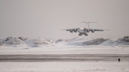 Passenger plane lands at the airport in winter. 