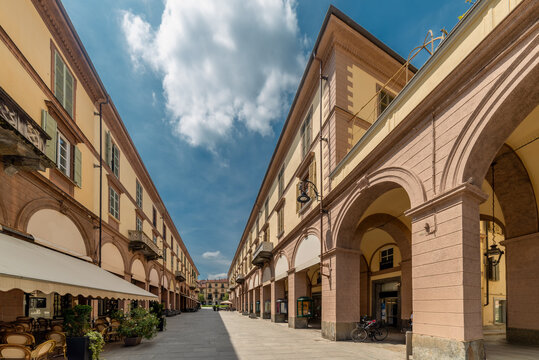 Saluzzo, Italy - June 11, 2024: Via Silvio Pellico the central pedestrian street with old buildings with arcades in the historic center with blue sky