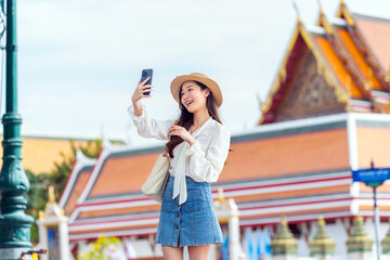 Joyful Asian Woman Taking Selfie at Famous Thai Landmark