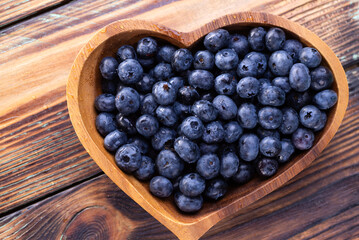 Fresh blueberries on heart-shaped plates on a wooden table