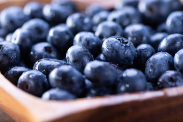 Fresh blueberries close up on a wooden plate