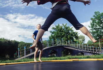 Trampoline amusement park. Father and son jump on an above-ground trampoline, the boy laughs. Family active holiday on weekends in summer