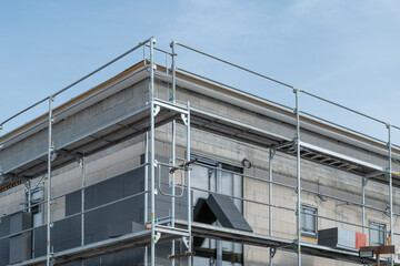 Obraz premium house construction process involves insulating the walls with modern thermal insulation materials. Exterior covering is applied at the construction site.