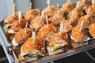 Beautifully decorated banquet catering table, with variety of with different food snacks appetizers on corporate birthday party event or wedding celebration, canape, salad, delicatessen setting