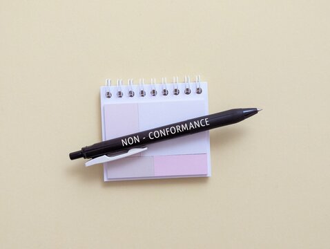 Pen, note pad with the word non-conformance.