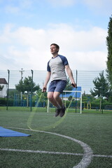 A young man in sportswear engages in a workout, using a sport tool for physical exercises on a...
