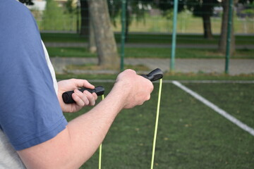 A young man in sportswear engages in a workout, using a sport tool for physical exercises on a...