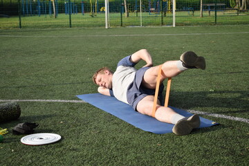 A young man in sportswear engages in a workout, using a sport tool for physical exercises on a...