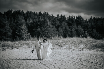 Valmiera, Latvia - September 9, 2023 - Black and white photo of a bride and groom walking on a...
