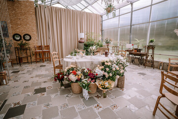 Valmiera, Latvia - September 9, 2023 - Elegant wedding reception table with floral arrangements, tableware, and decor in a bright, airy venue.