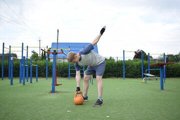 A young man in sportswear engages in a workout, using a sport tool for physical exercises on a...
