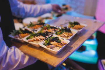 Beautifully decorated banquet catering table, with variety of with different food snacks appetizers on corporate birthday party event or wedding celebration, canape, salad, delicatessen setting