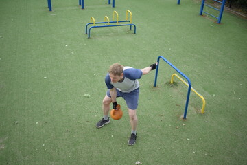 A young man in sportswear engages in a workout, using a sport tool for physical exercises on a...