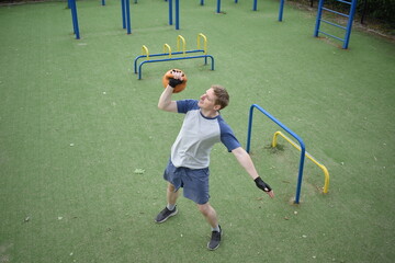 A young man in sportswear engages in a workout, using a sport tool for physical exercises on a...