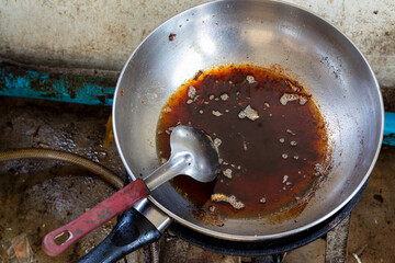 Frying pan with used oil on a stove after cooking