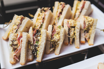 Beautifully decorated banquet catering table, with variety of with different food snacks appetizers on corporate birthday party event or wedding celebration, canape, salad, delicatessen setting