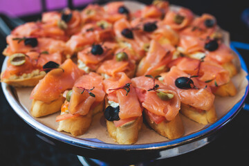 Beautifully decorated banquet catering table, with variety of with different food snacks appetizers on corporate birthday party event or wedding celebration, canape, salad, delicatessen setting