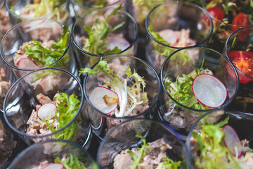 Beautifully decorated banquet catering table, with variety of with different food snacks appetizers on corporate birthday party event or wedding celebration, canape, salad, delicatessen setting