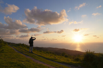 Fototapeta premium Northern route. Hiker at sunset on the road to Santiago - Camino del norte, mount Jaizkibel, Euskadi