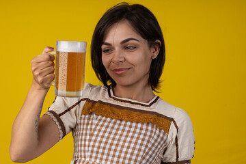 Beautiful young woman wearing typical ''festa junina'' costume holding a mug of cold beer