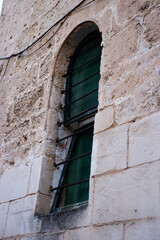 typical menorca window in stone building with wooden shutters