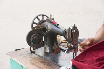 Tailor using old worn out sewing machine
