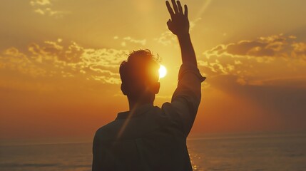 Silhouette of a person waving at a golden sunset by the ocean, capturing a peaceful and heartwarming moment of farewell.