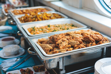 Beautifully decorated catering banquet table with different main course hot food dishes and garnish, with rice, chicken, salmon fish, lamb, vegetables and kebab on party event wedding celebration