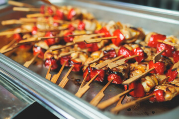 Beautifully decorated catering banquet table with different main course hot food dishes and garnish, with rice, chicken, salmon fish, lamb, vegetables and kebab on party event wedding celebration