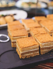 Beautiful multicolored decorated baked sweet tasty candy bar dessert selection with cake, pie and pastries selection, catering banquet table on kids children party, coffee break buffet at a conference