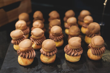 Beautiful multicolored decorated baked sweet tasty candy bar dessert selection with cake, pie and pastries selection, catering banquet table on kids children party, coffee break buffet at a conference