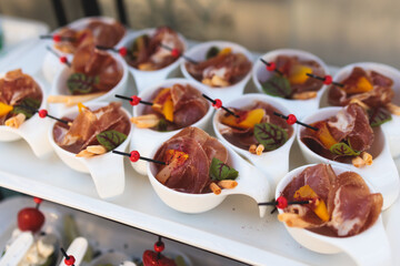 Beautifully decorated luxury banquet catering table, with variety of with different food snacks appetizers on corporate birthday party event wedding celebration, canape, salad, delicatessen variety
