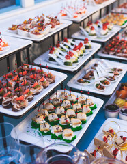 Beautifully decorated luxury banquet catering table, with variety of with different food snacks appetizers on corporate birthday party event wedding celebration, canape, salad, delicatessen variety