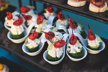 Beautifully decorated luxury banquet catering table, with variety of with different food snacks appetizers on corporate birthday party event wedding celebration, canape, salad, delicatessen variety