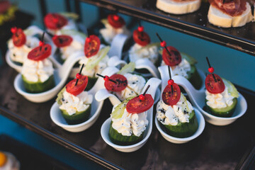 Beautifully decorated luxury banquet catering table, with variety of with different food snacks appetizers on corporate birthday party event wedding celebration, canape, salad, delicatessen variety