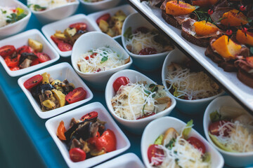 Beautifully decorated luxury banquet catering table, with variety of with different food snacks appetizers on corporate birthday party event wedding celebration, canape, salad, delicatessen variety