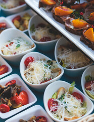 Beautifully decorated luxury banquet catering table, with variety of with different food snacks appetizers on corporate birthday party event wedding celebration, canape, salad, delicatessen variety