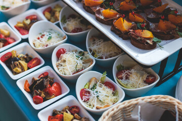 Beautifully decorated luxury banquet catering table, with variety of with different food snacks appetizers on corporate birthday party event wedding celebration, canape, salad, delicatessen variety