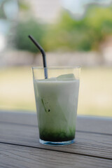 Glass of Iced Matcha Latte on Wooden Table