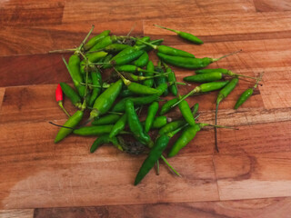 green bird's eye chili on a wooden cutting board