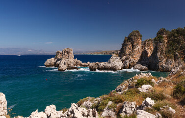 Fototapeta premium View across tranquil cove to the Faraglioni, Scopello